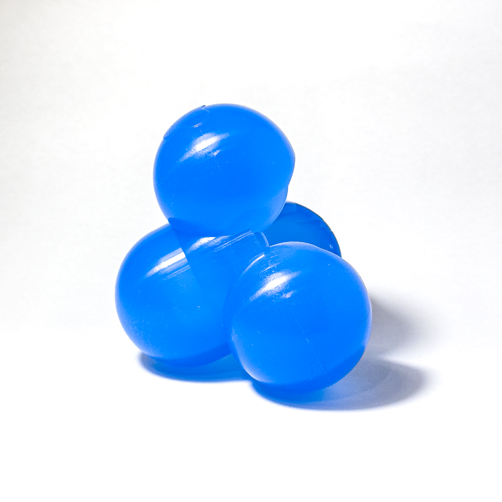 Small, solid blue silicone structure comprised of four circular nodes, tipped on its side and viewed from the side