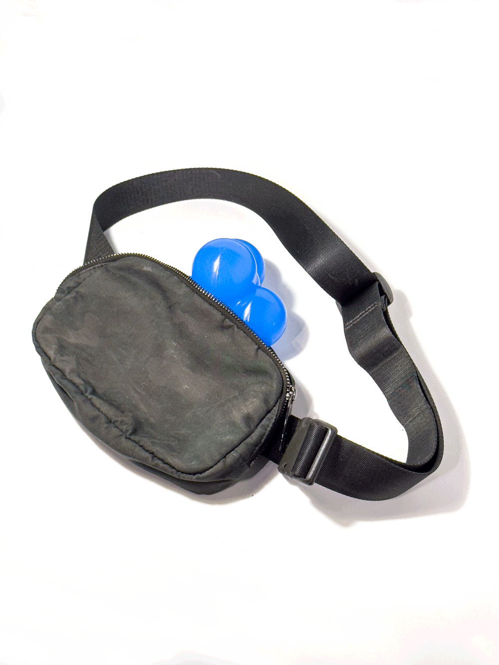 Small, solid blue silicone structure comprised of four circular nodes, pictured partially inside a strap bag